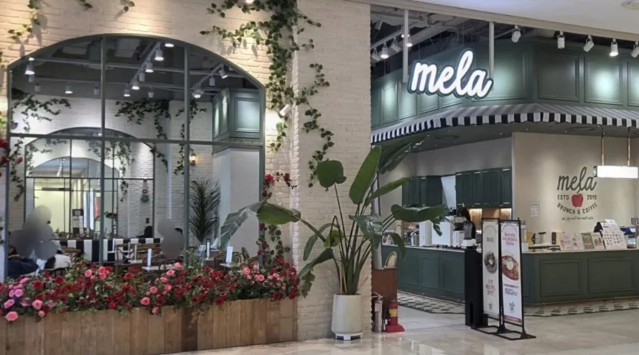 Entrance to Mela Times Square with arched windows and brick exterior