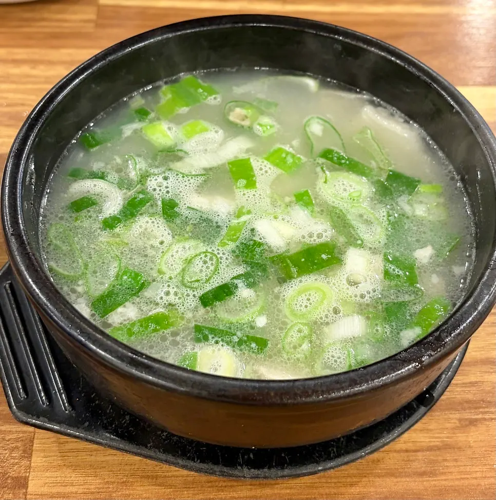 Dwaeji gukbap with milky-white broth in a stone pot