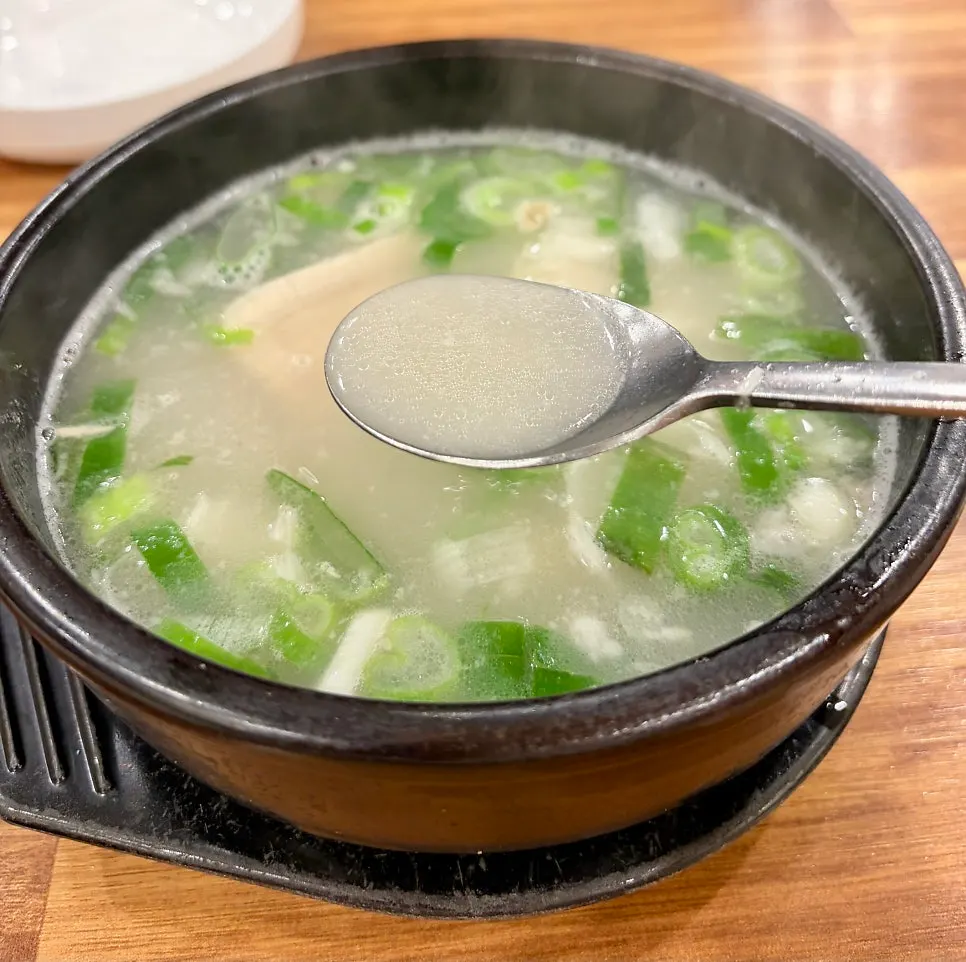 Dwaeji gukbap topped with pork, chives, and green onion