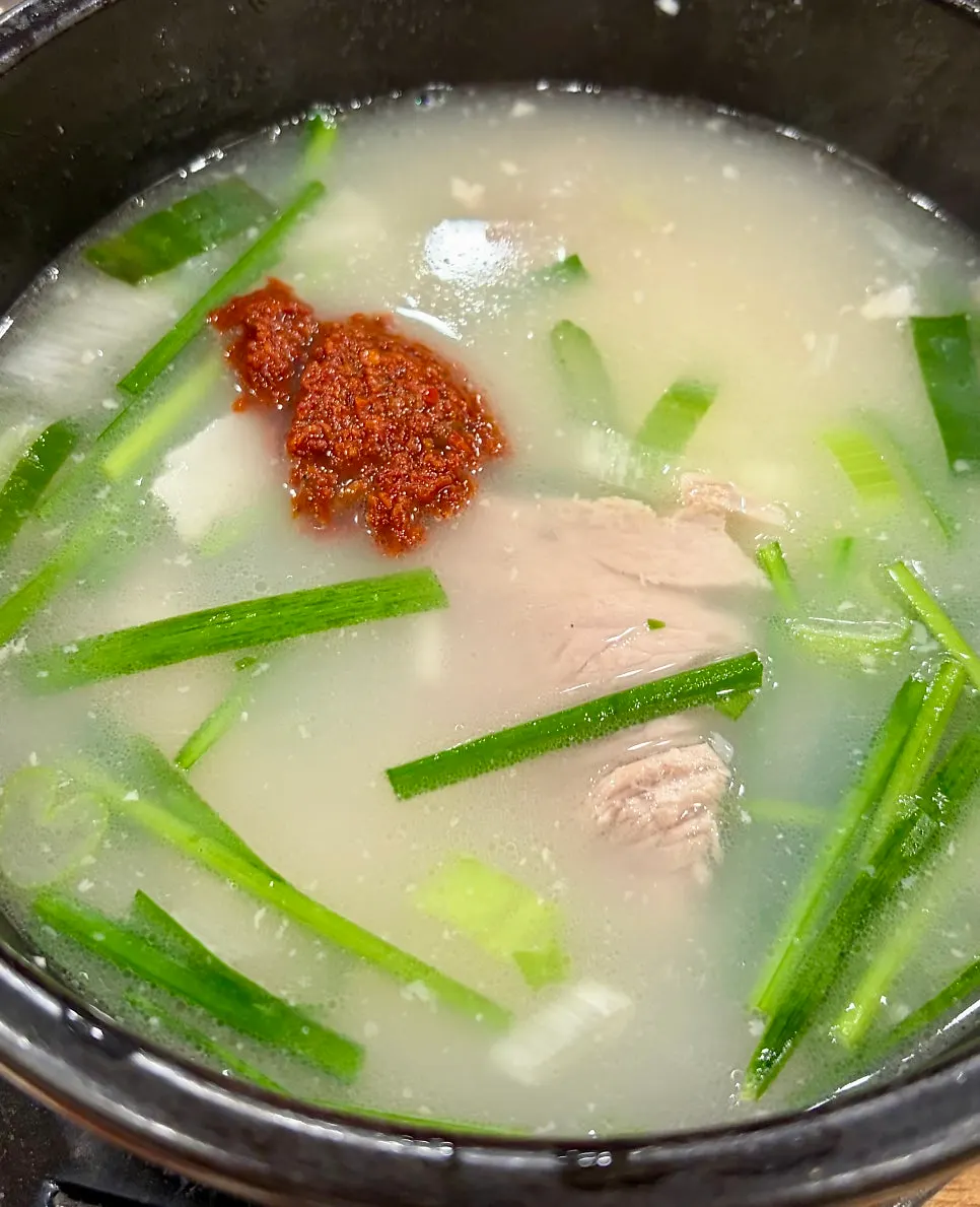 A bite of dwaeji gukbap eaten with rice