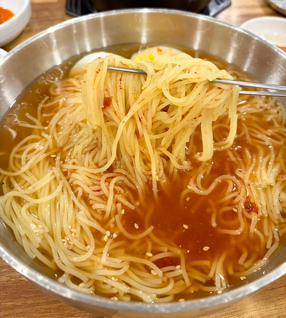 Mul milmyeon topped with seasoning sauce and egg