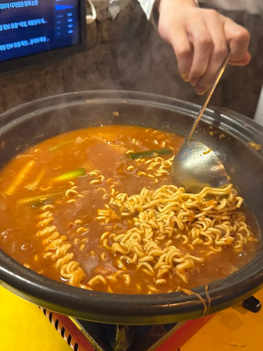 Ramyeon noodles being added to the crab stew