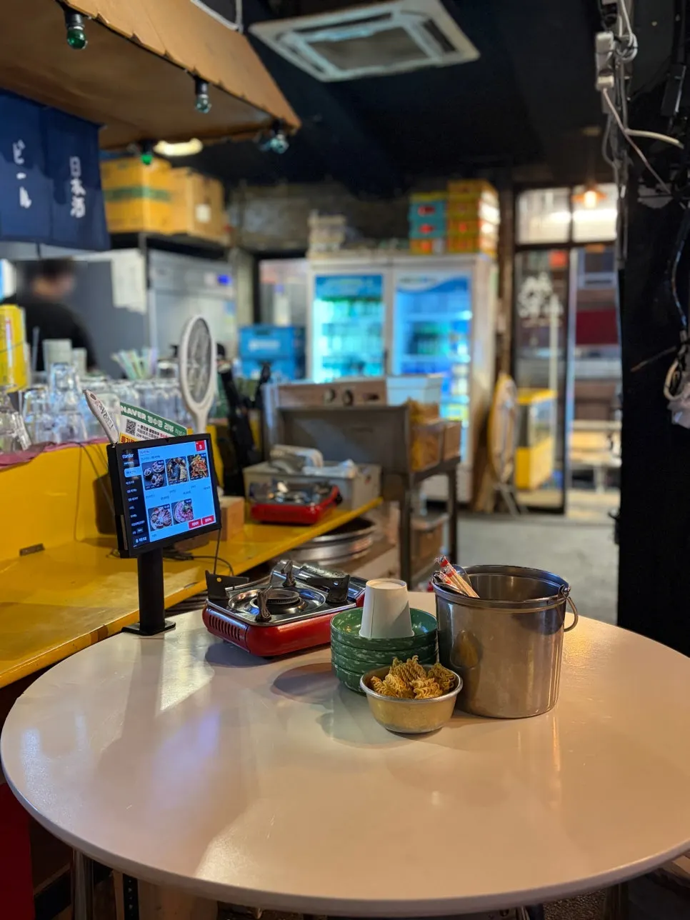 Basic table setup with ramyeontang, small plates, and a burner