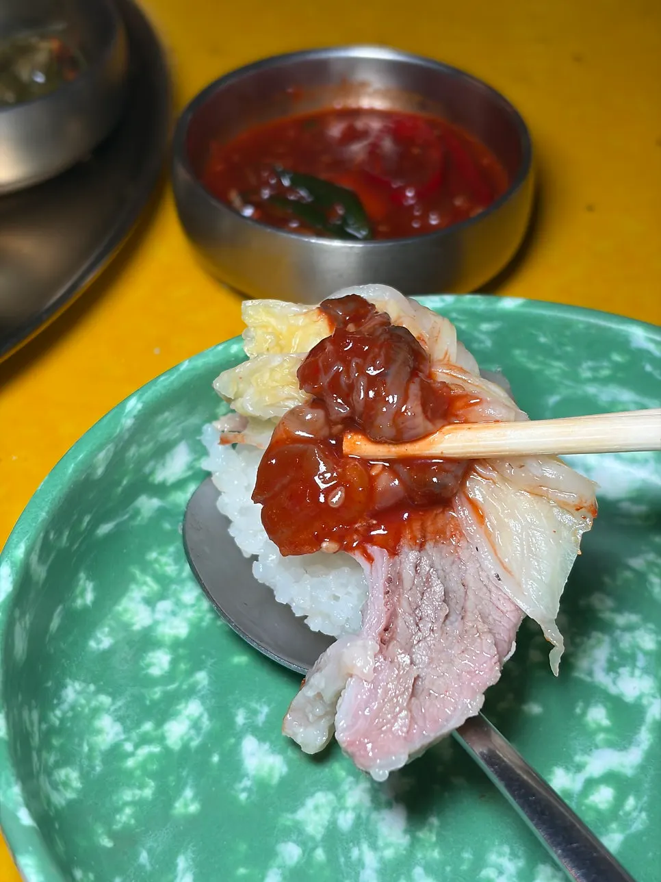 A piece of suyuk topped with oyster jeot and baek-kimchi