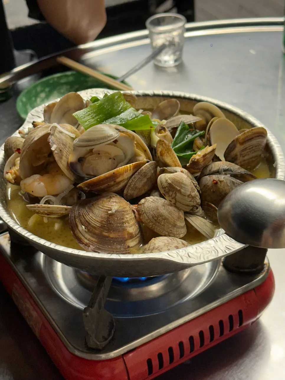 Pot of vongole soju stew on a portable burner