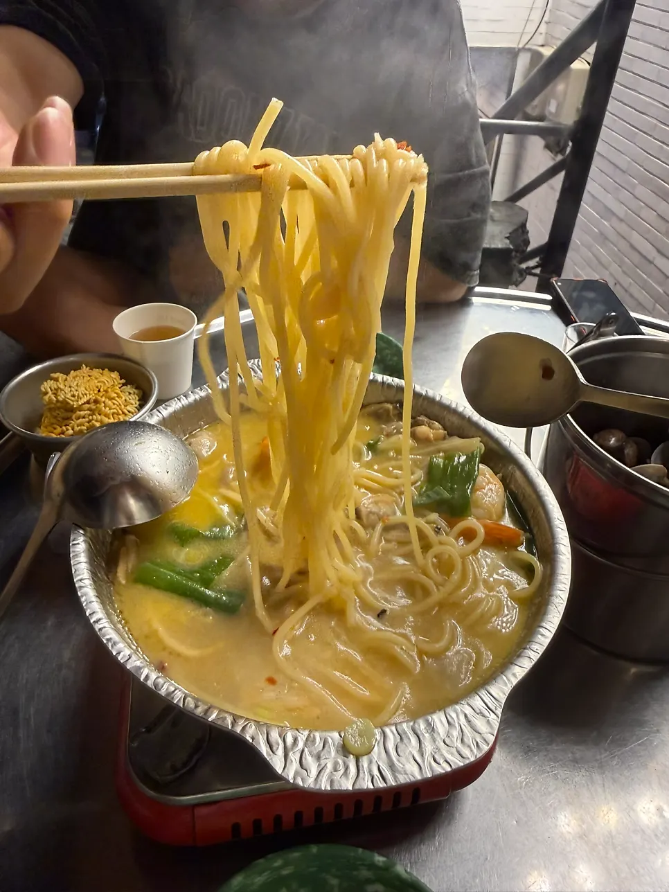 Pasta noodles served with vongole soju stew broth