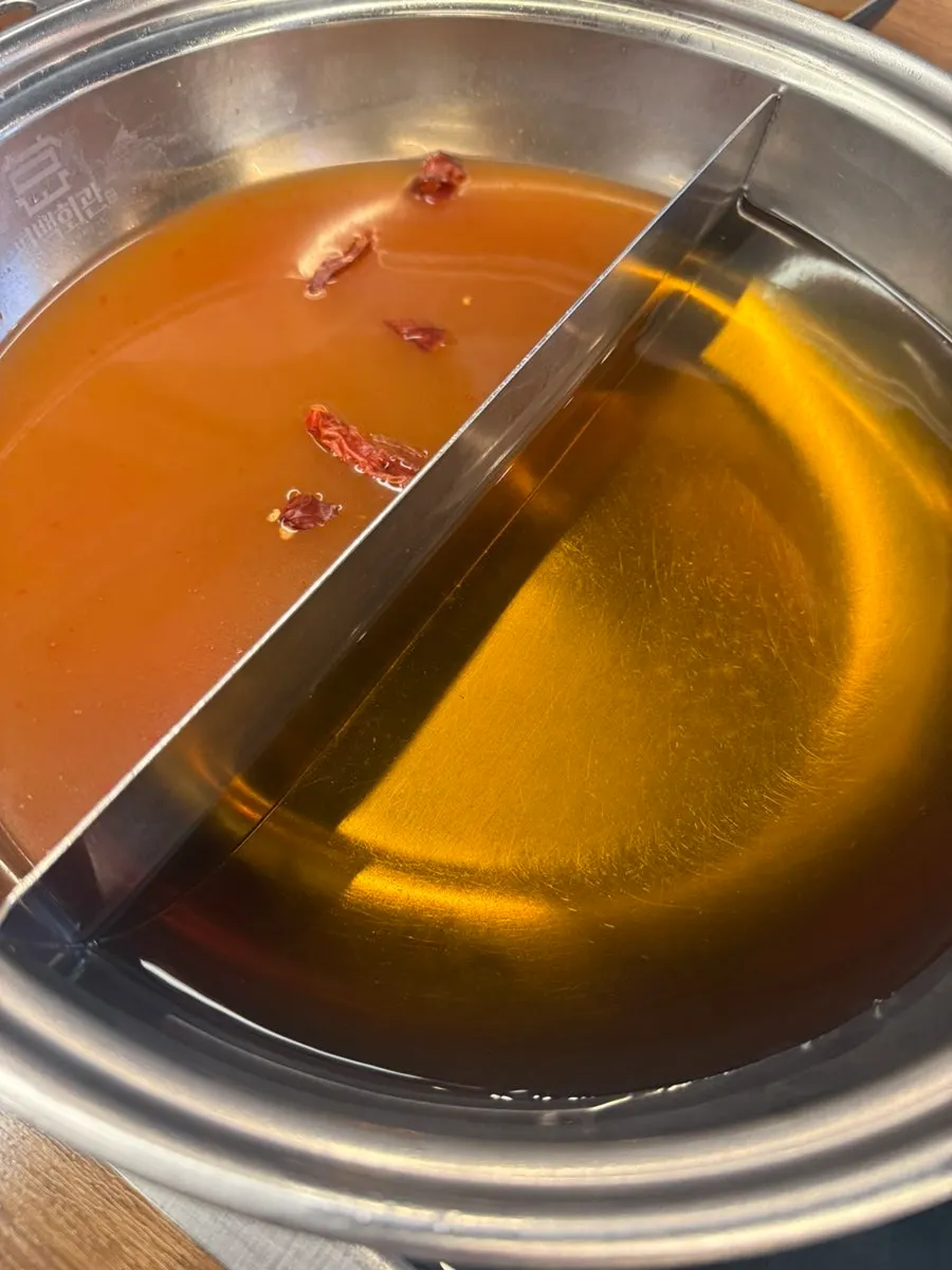 Two shabu-shabu pots, basic and spicy broth