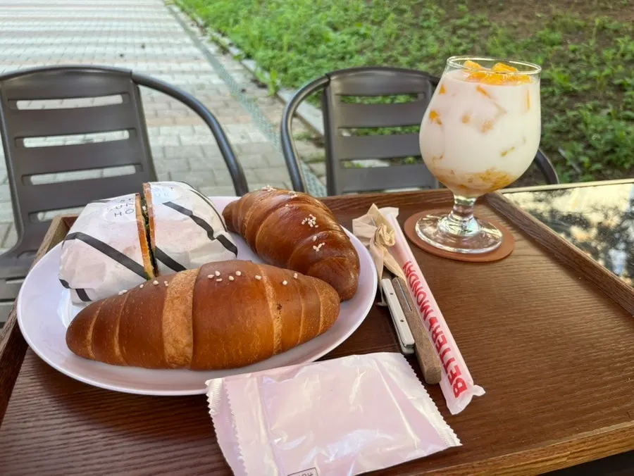 Table spread of salt bread, jambon sandwich and mango latte