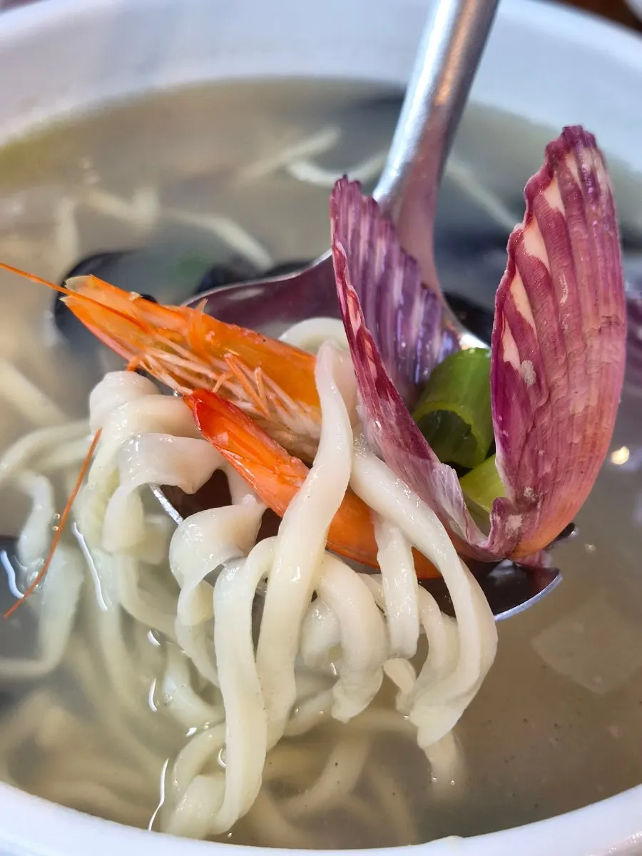 Table spread of octopus stir-fry and kalguksu eaten side by side