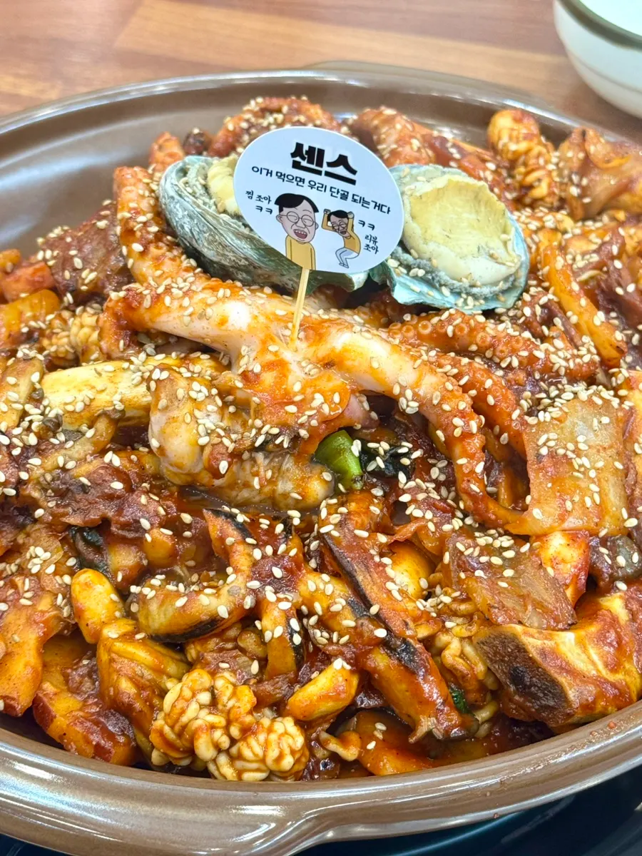 A plate of the seafood stew topped with self-serve bean sprouts