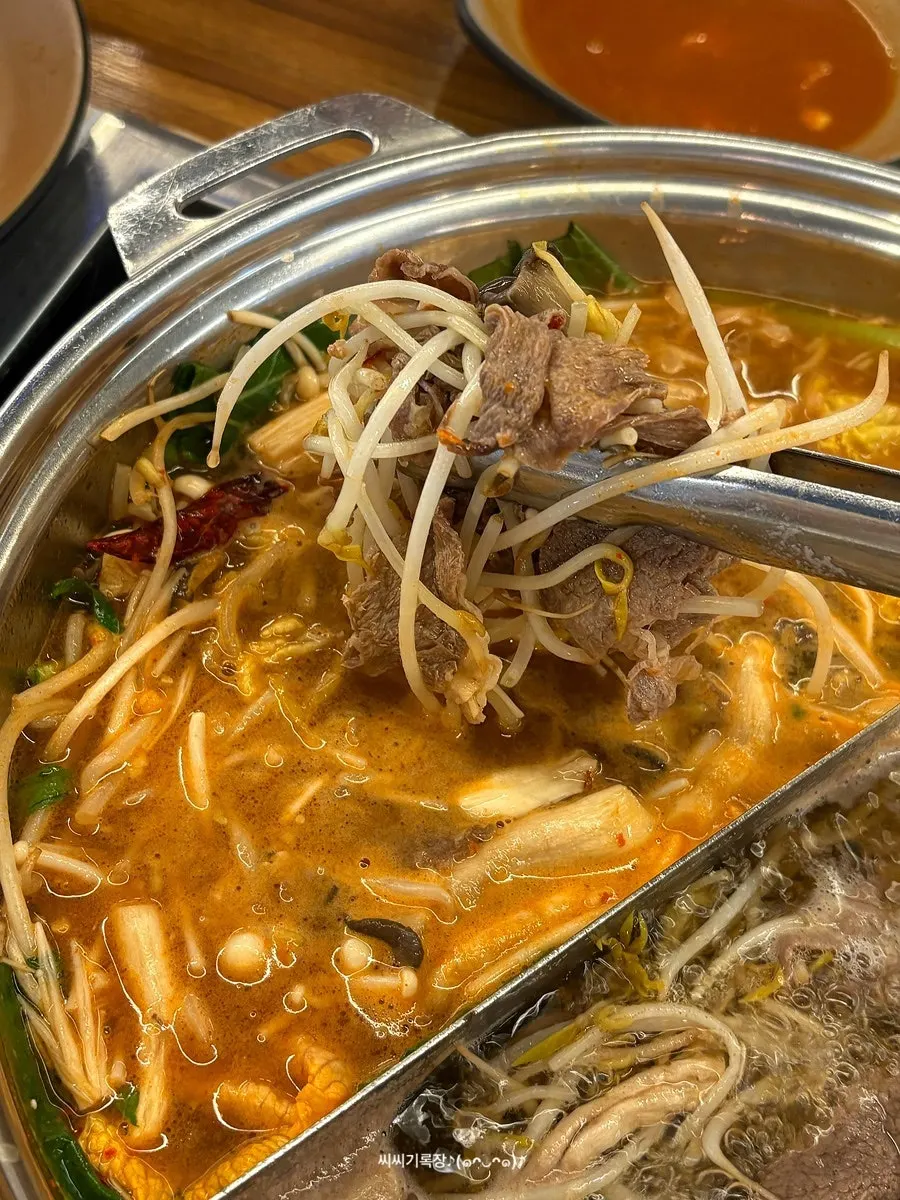 Meat and vegetables dipped in the spicy mushroom broth