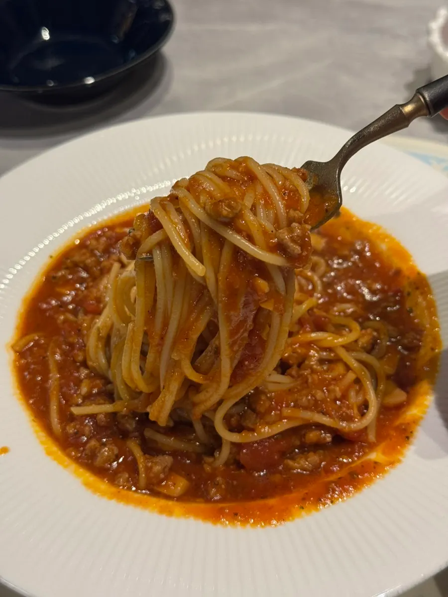 Fork lifting a bite of tomato beef pasta