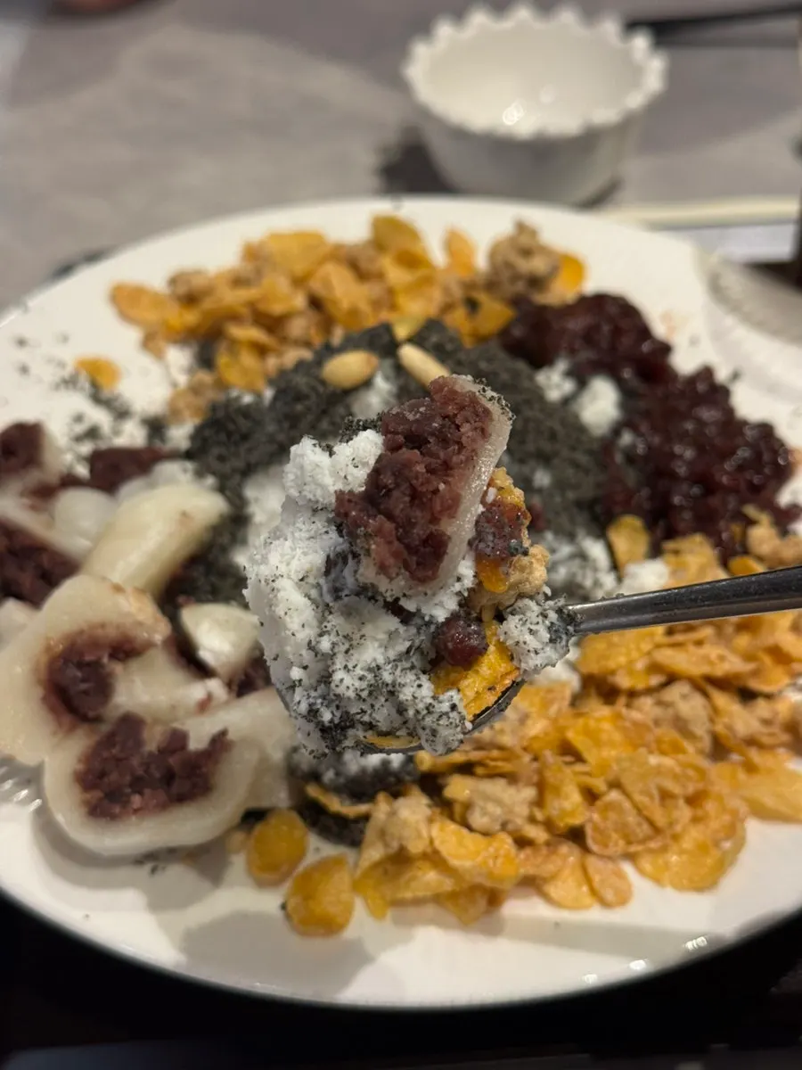 Black sesame snow bingsu topped with nuts and rice cakes
