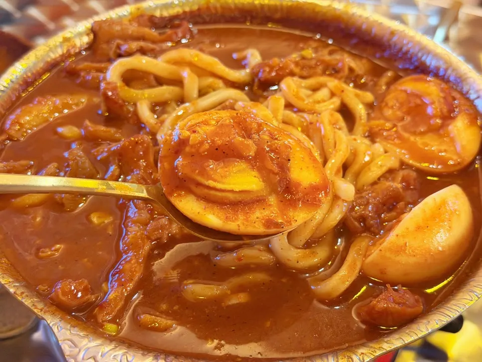 Boiled egg dipped in sauce alongside dakbal