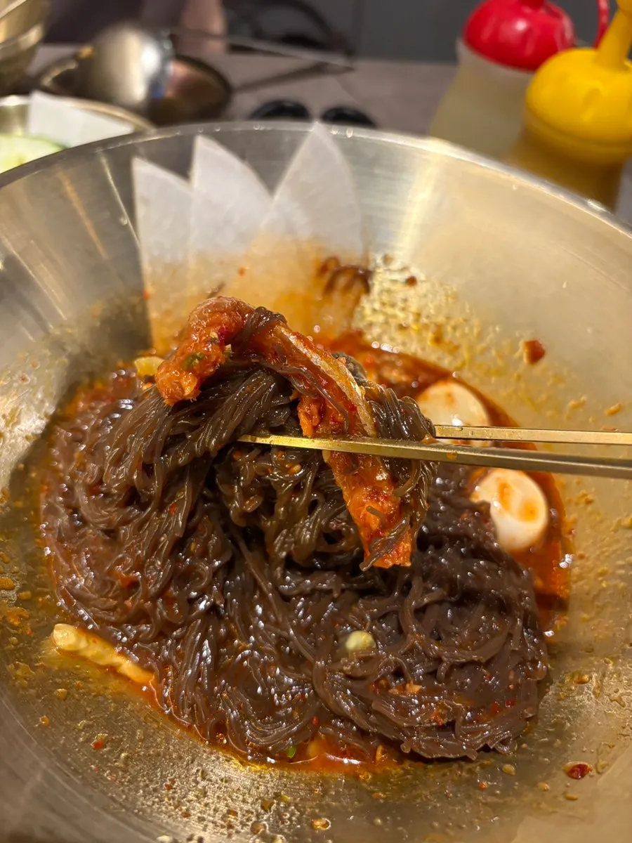 검은 면에 양념을 비빈 코다리 비빔냉면