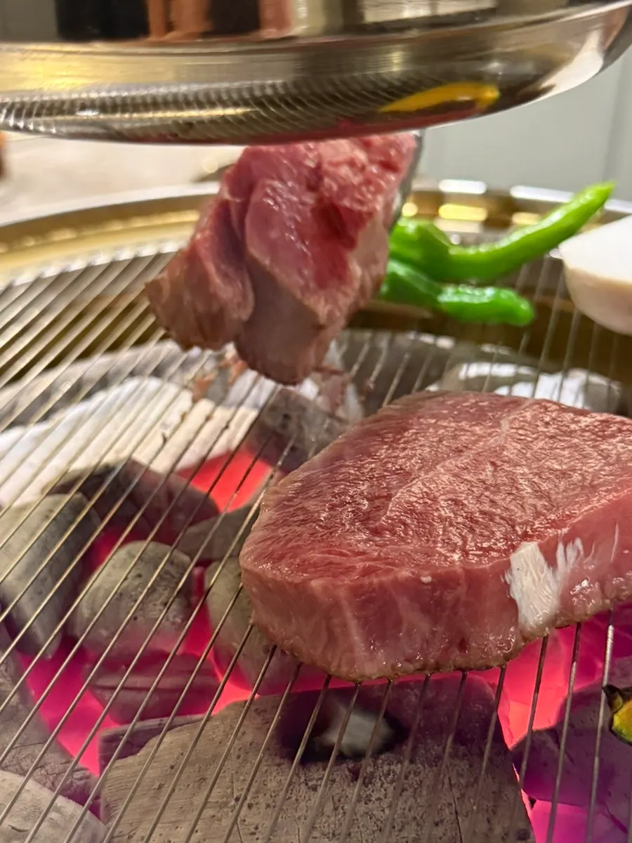 Hanwoo sirloin and chuck flap grilling over charcoal
