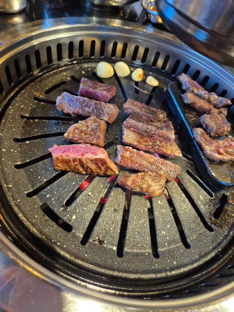집게로 고기를 뒤집으며 굽는 모습