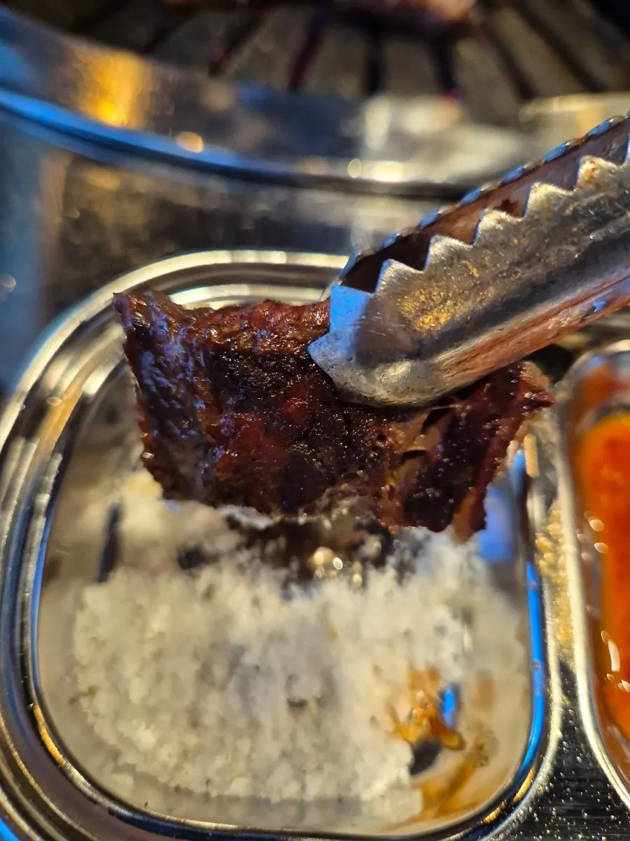 소금에 찍어 먹기 전 구워진 소고기 한 점