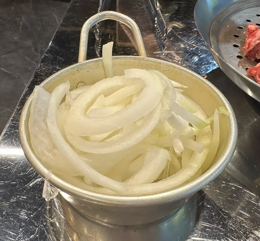 A piece of grilled beef with pickled onions