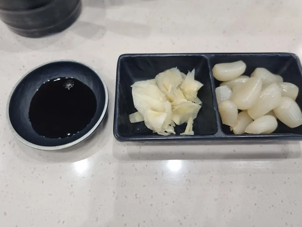 Soy sauce, wasabi, and pickled ginger condiments for the sushi