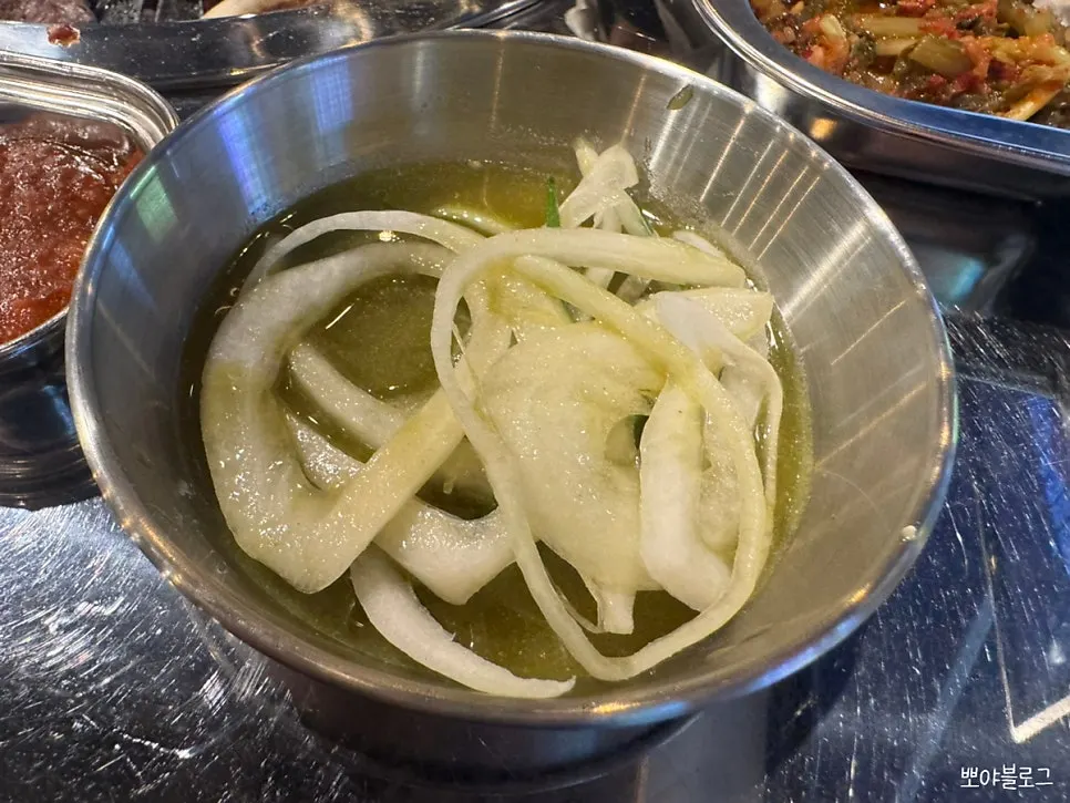 Shredded scallion salad, pickled onions, and kimchi sides