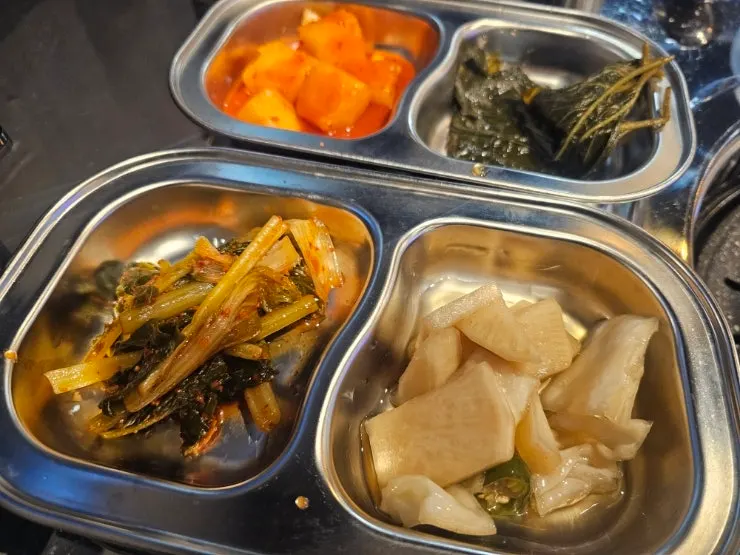 Basic side dish spread including pickled onions and yeolmu kimchi