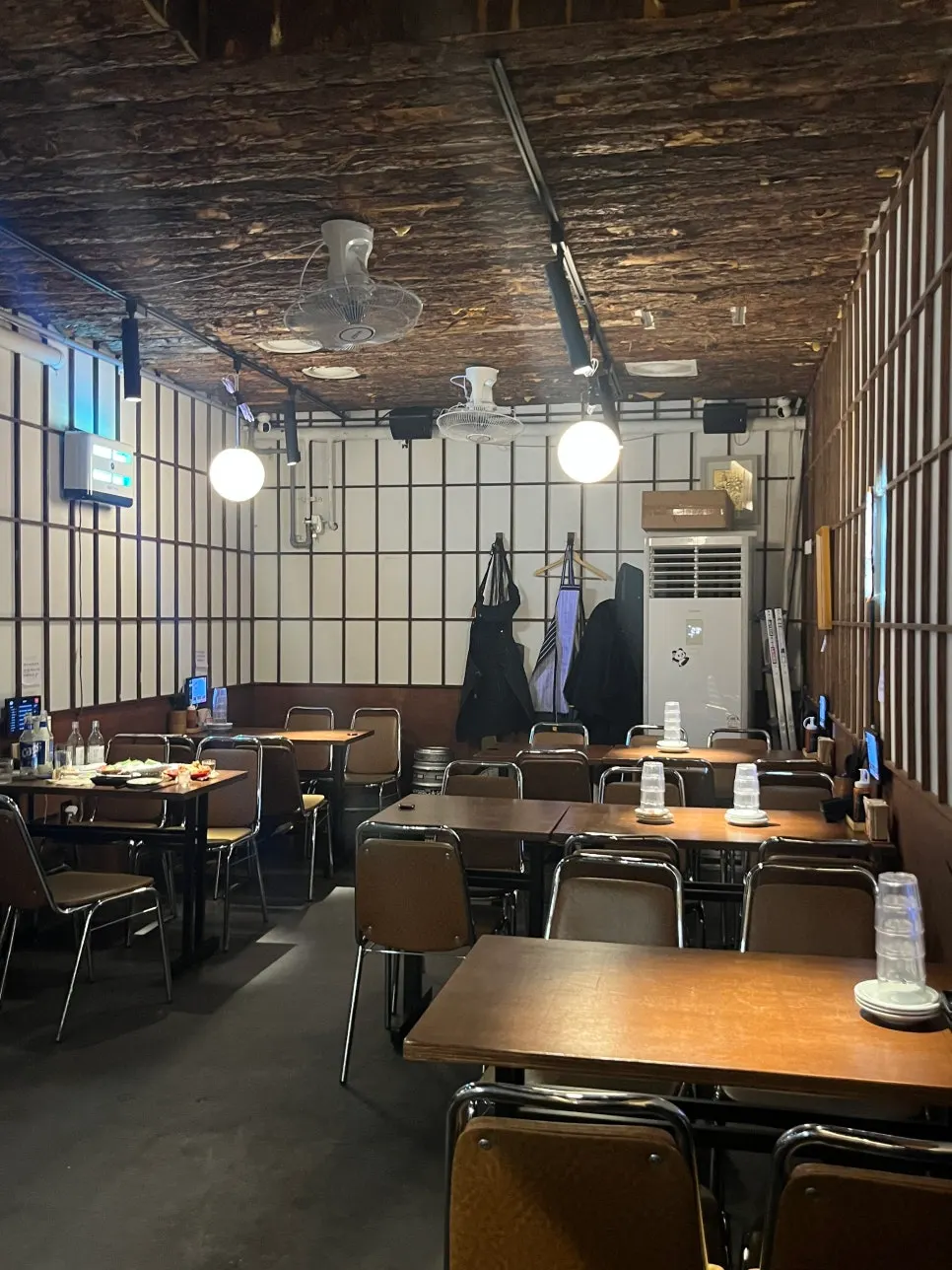 Izakaya interior with sake bottles lined up on the ceiling