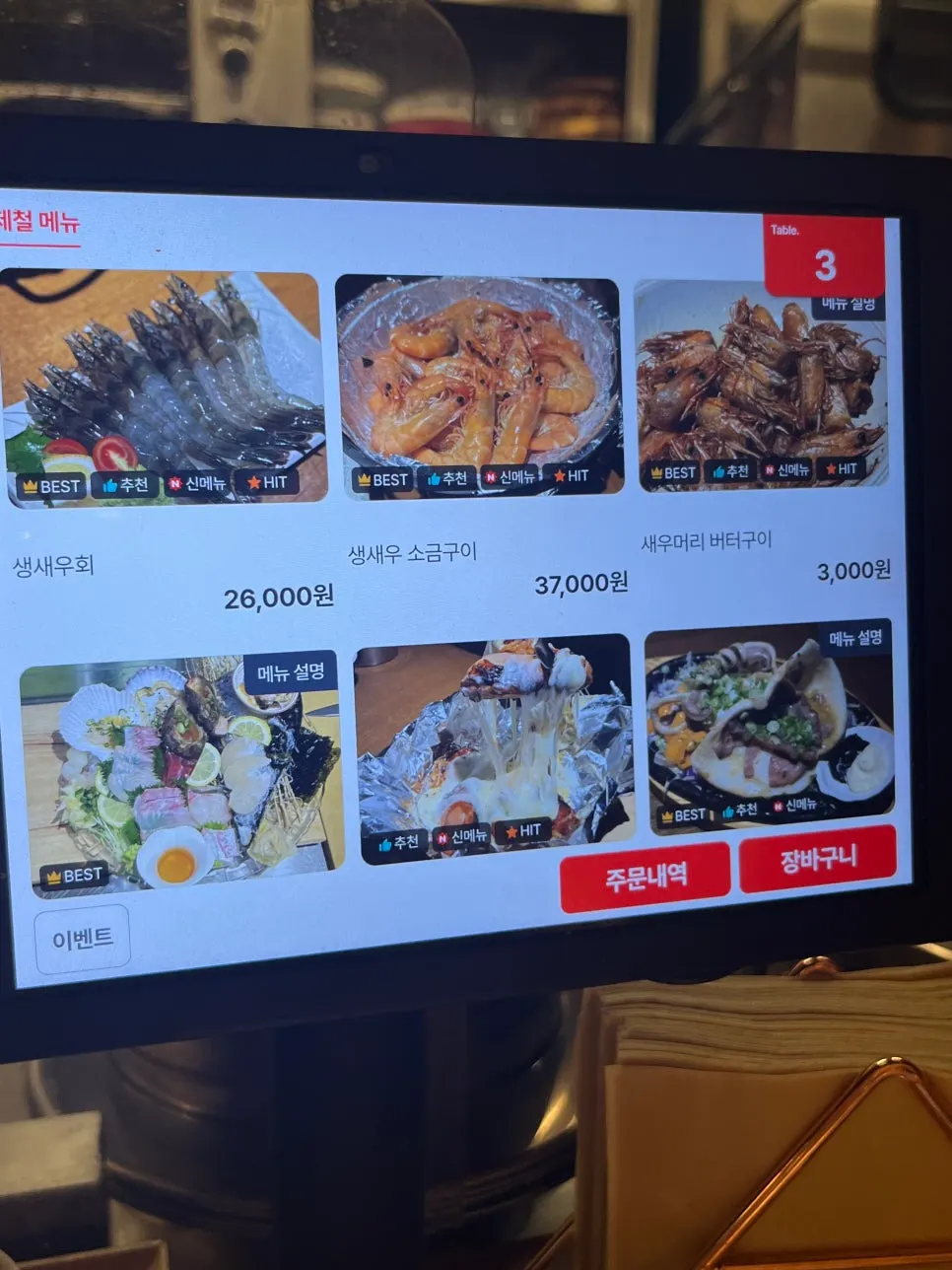 Menu board showing live sweet shrimp sashimi and other seafood dishes