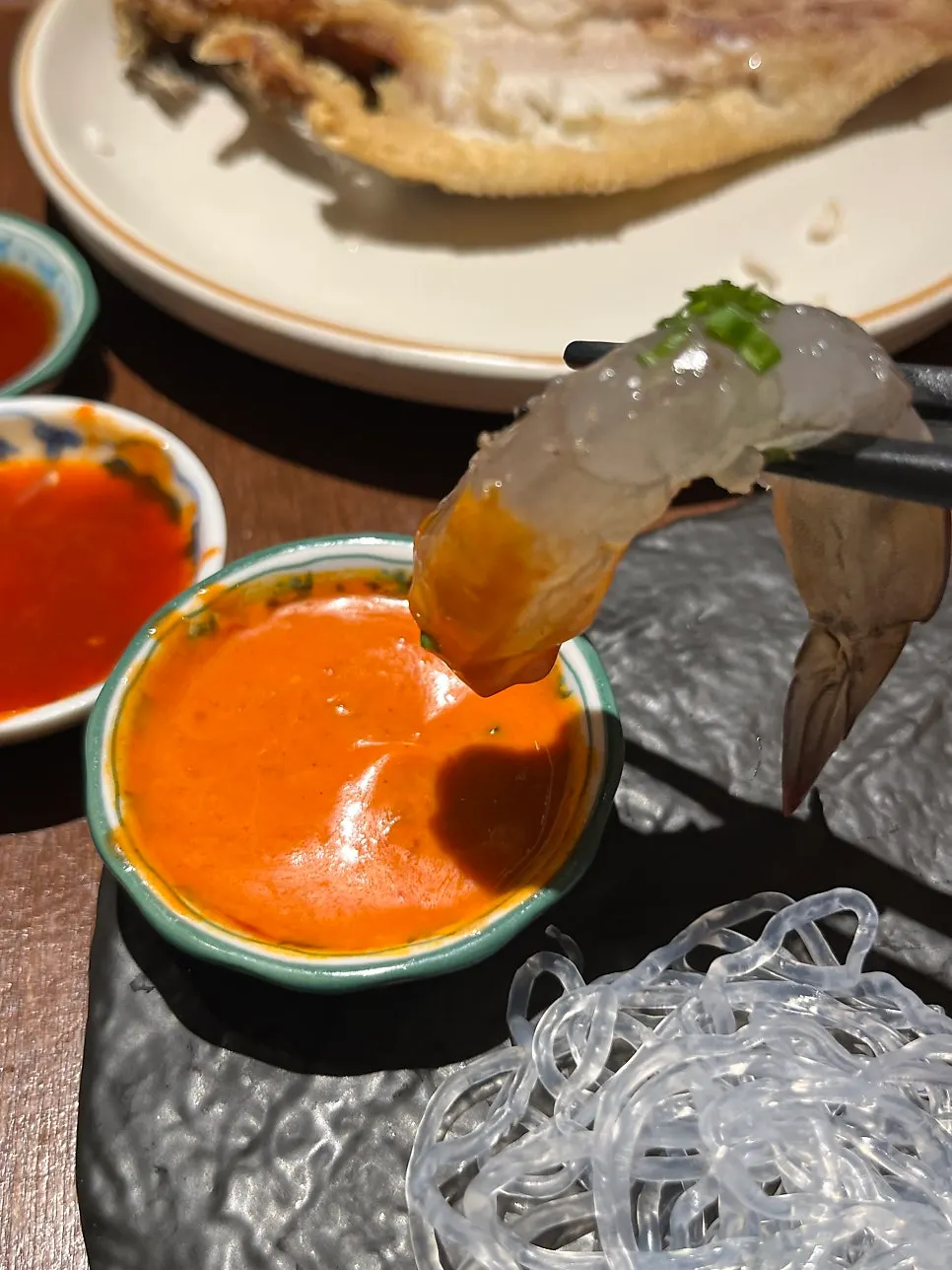 A single shrimp dipped in buldak mayo sauce
