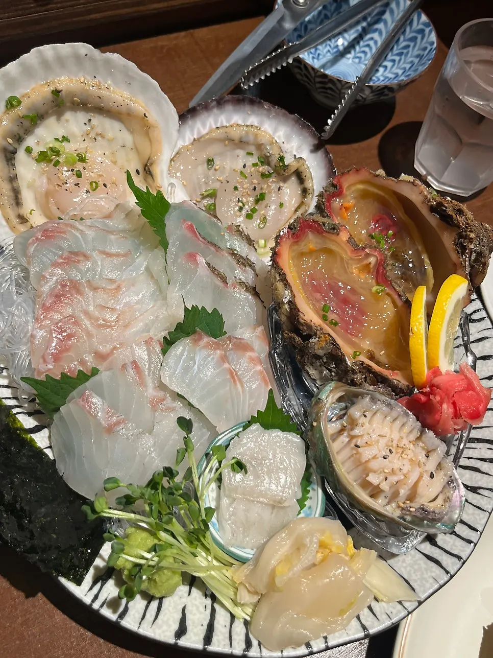 Table with the mixed platter and live sweet shrimp sashimi