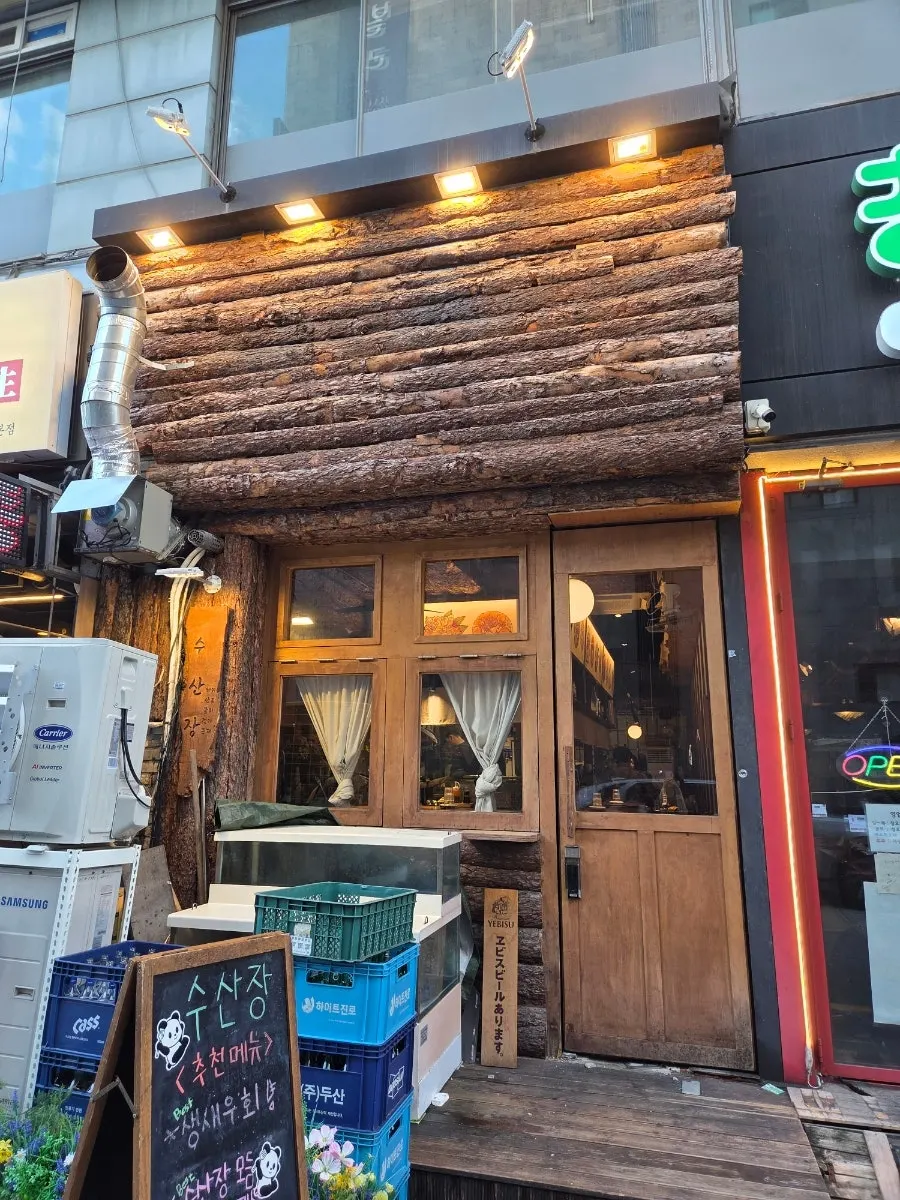 Susan Jang exterior with logs and warm wood tones