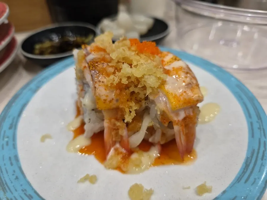 Salmon sushi topped with a large piece of salmon tail