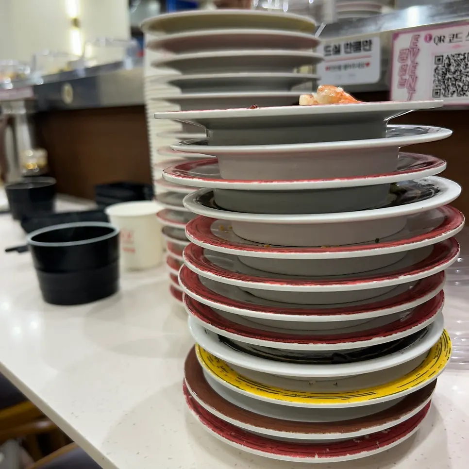 Conveyor-belt sushi counter seating with transparent partitions