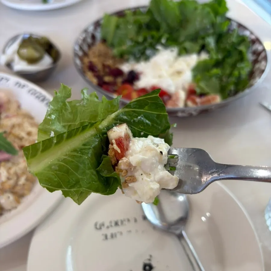 A bite of burrata salad sprinkled with granola