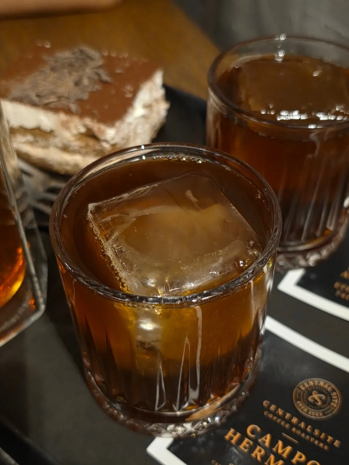 Iced coffee with large square ice cubes alongside grapefruit lemon tea