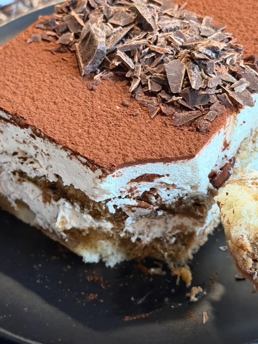 A spoonful of tiramisu topped with chocolate