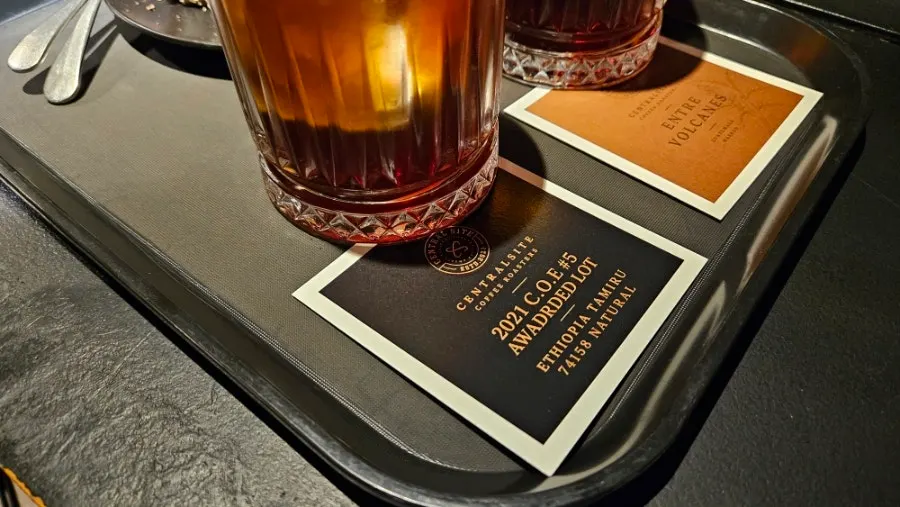 Paper describing the coffee alongside a cup of brewing coffee