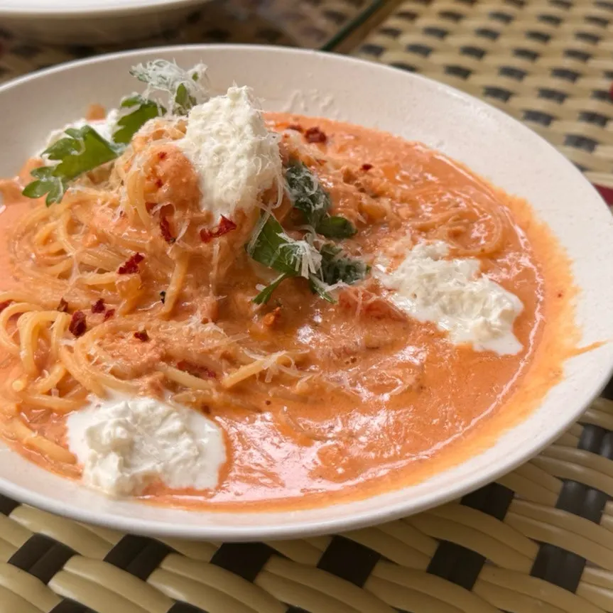 A plate of rosé crab pasta topped with cheese