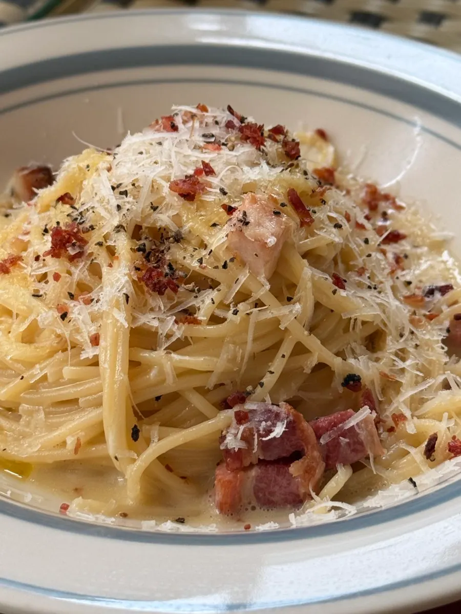 Close-up of carbonara sauce clinging thickly to the noodles