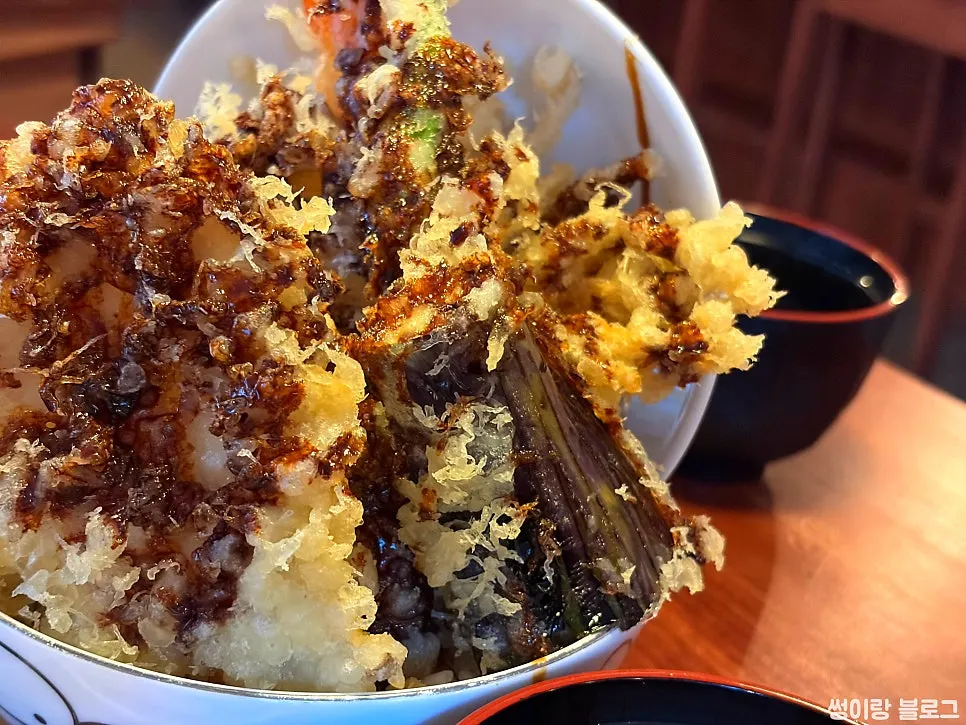 Side view of tendon with vegetable tempura on top