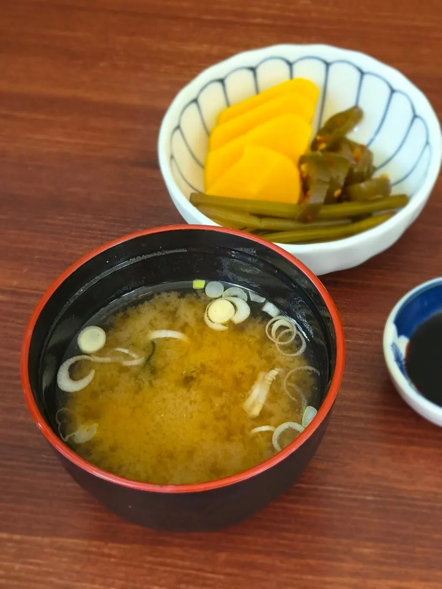 Basic table setting with pickled chili peppers and clear broth