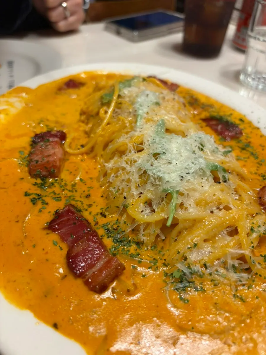 Rosé pasta topped with thick bacon