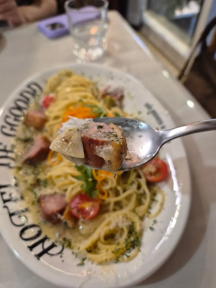 厚切りの燻製鴨と麺を持ち上げた様子