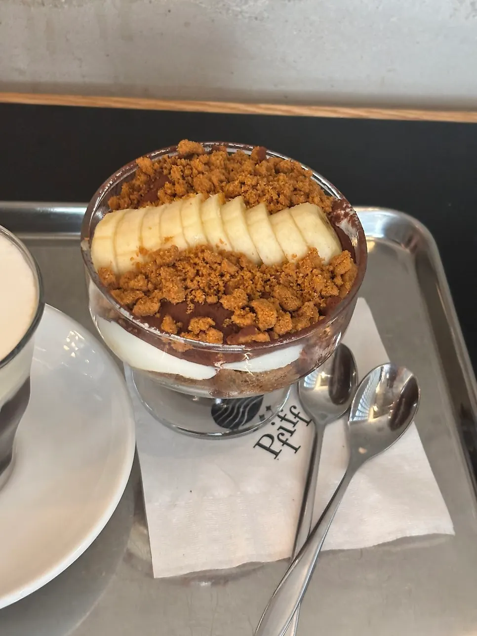 Plate of tiramisu topped with banana and crumble