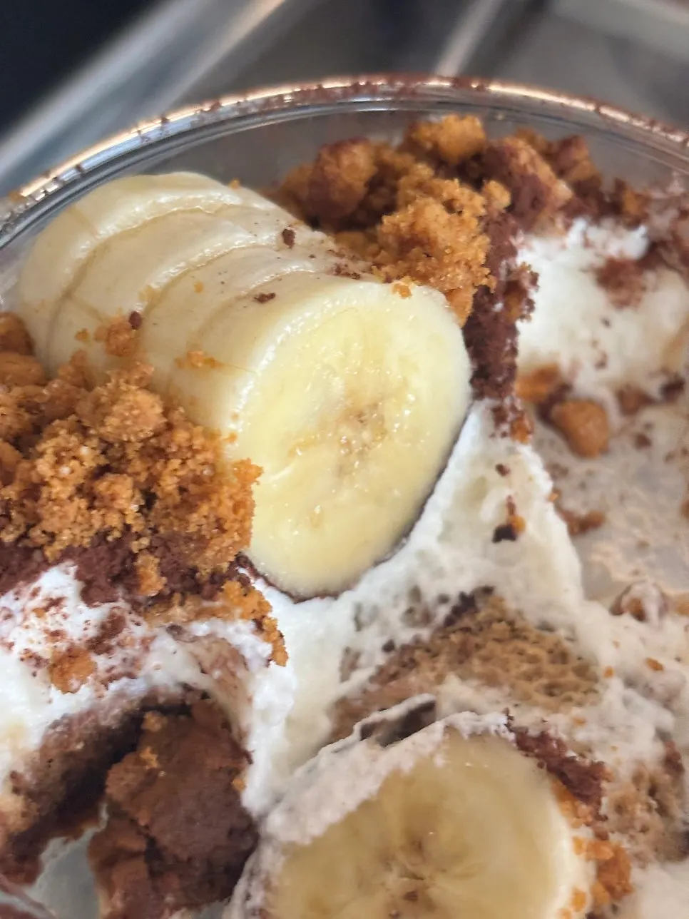 A bite of banana tiramisu showing the chocolate coating