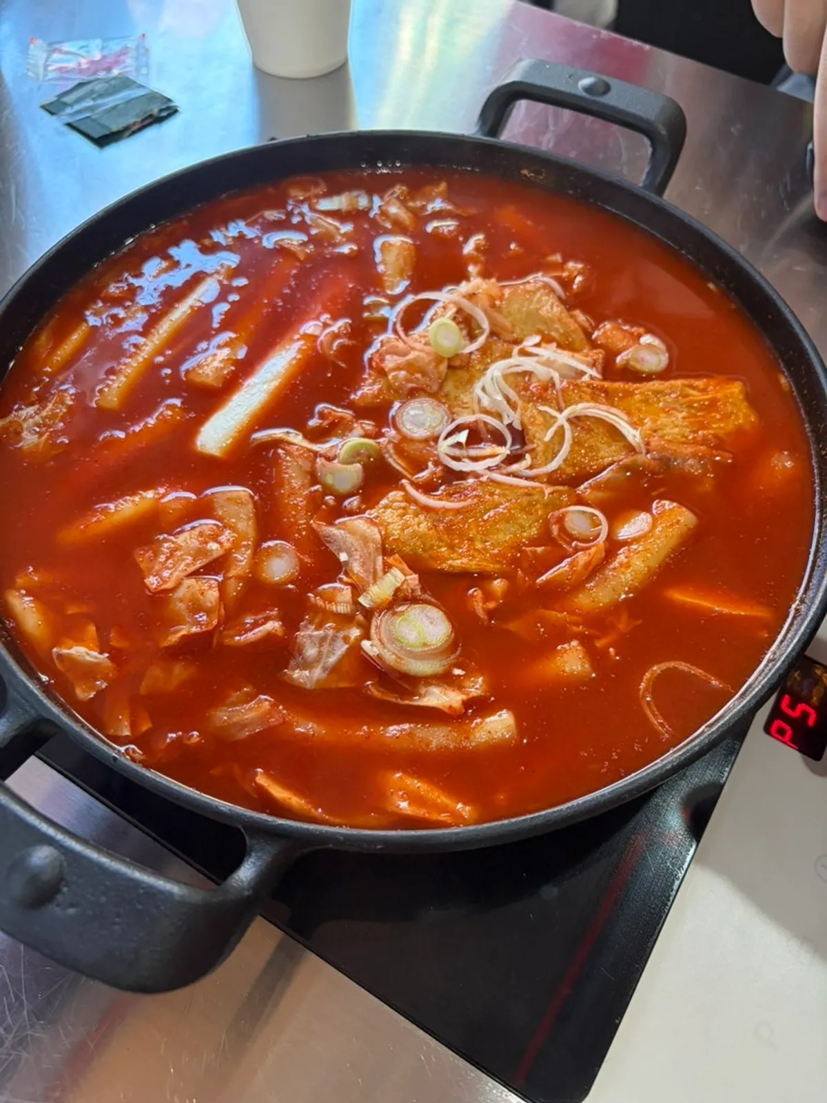 A chewy bite of tteokbokki coated in sauce
