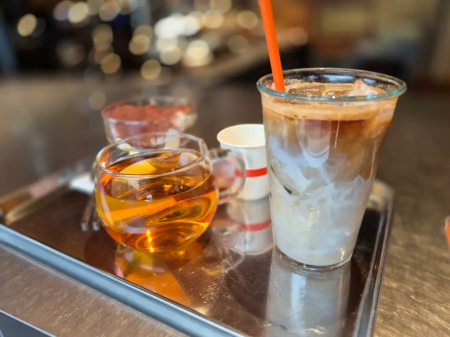 A tray with iced latte, rooibos tea, and tiramisu