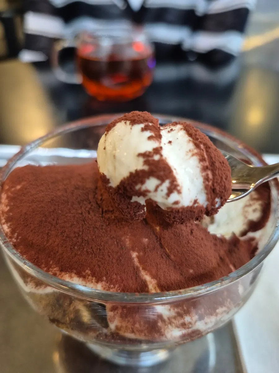 A spoonful of tiramisu lifted from the cup