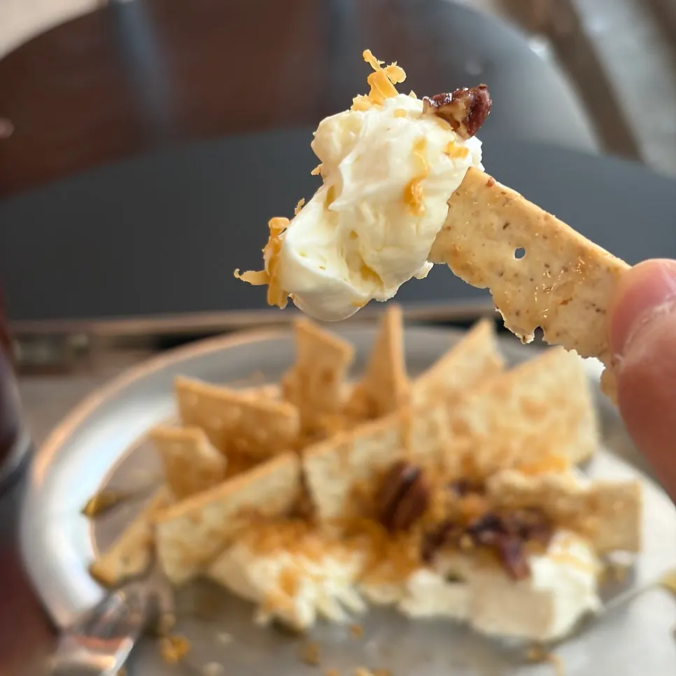 A cracker piece topped with honey and cheese