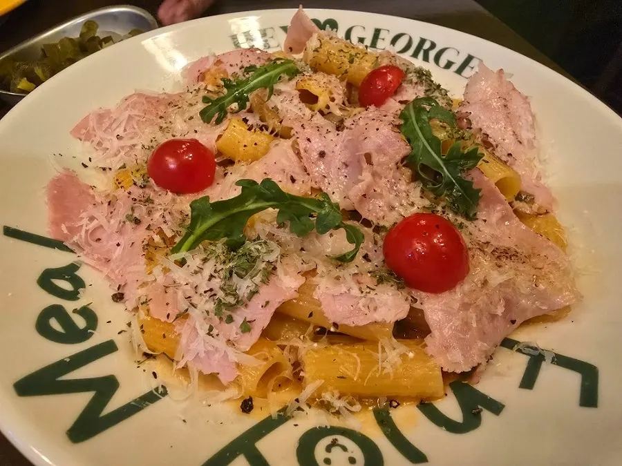 Jambon pasta topped with arugula and tomato